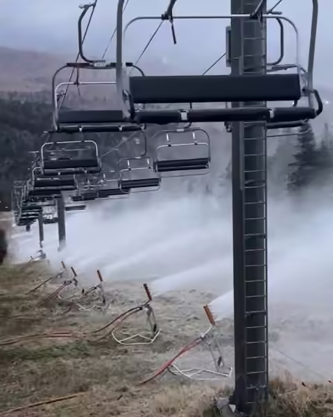 Snow guns firing under an empty chairlift at Killington, Vermont, before opening day